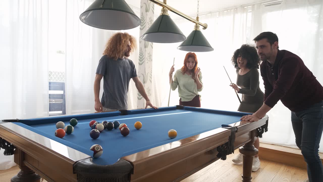 Black woman successfully hitting pool ball