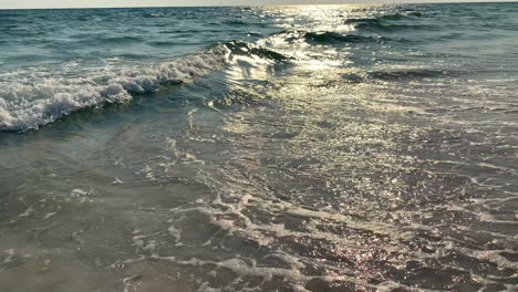 cámara lenta de olas golpeando la playa al atardecer