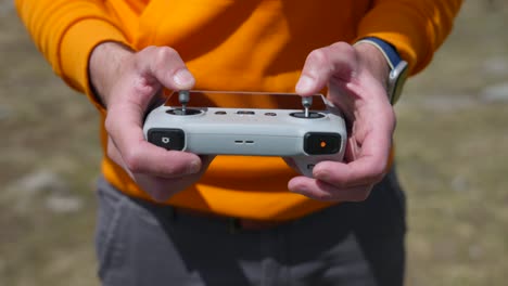 unrecognisable drone pilot holding controller, fully concentrate while flying