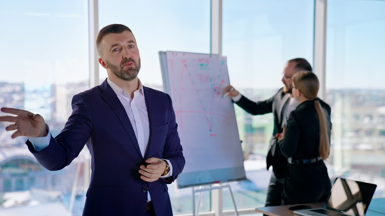Bearded businessman talking about his business project. Portrait of an entrepreneur in office center. Business colleagues working on background of panoramic window view with a city landscape.