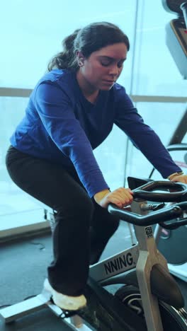 young woman doing spinning exercise at the gym