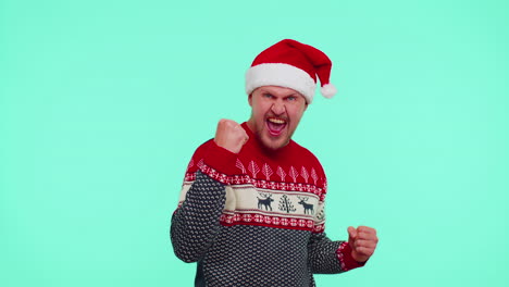 Cheerful-man-in-red-sweater-Christmas-Santa-shouting,-celebrating-success,-winning,-goal-achievemen