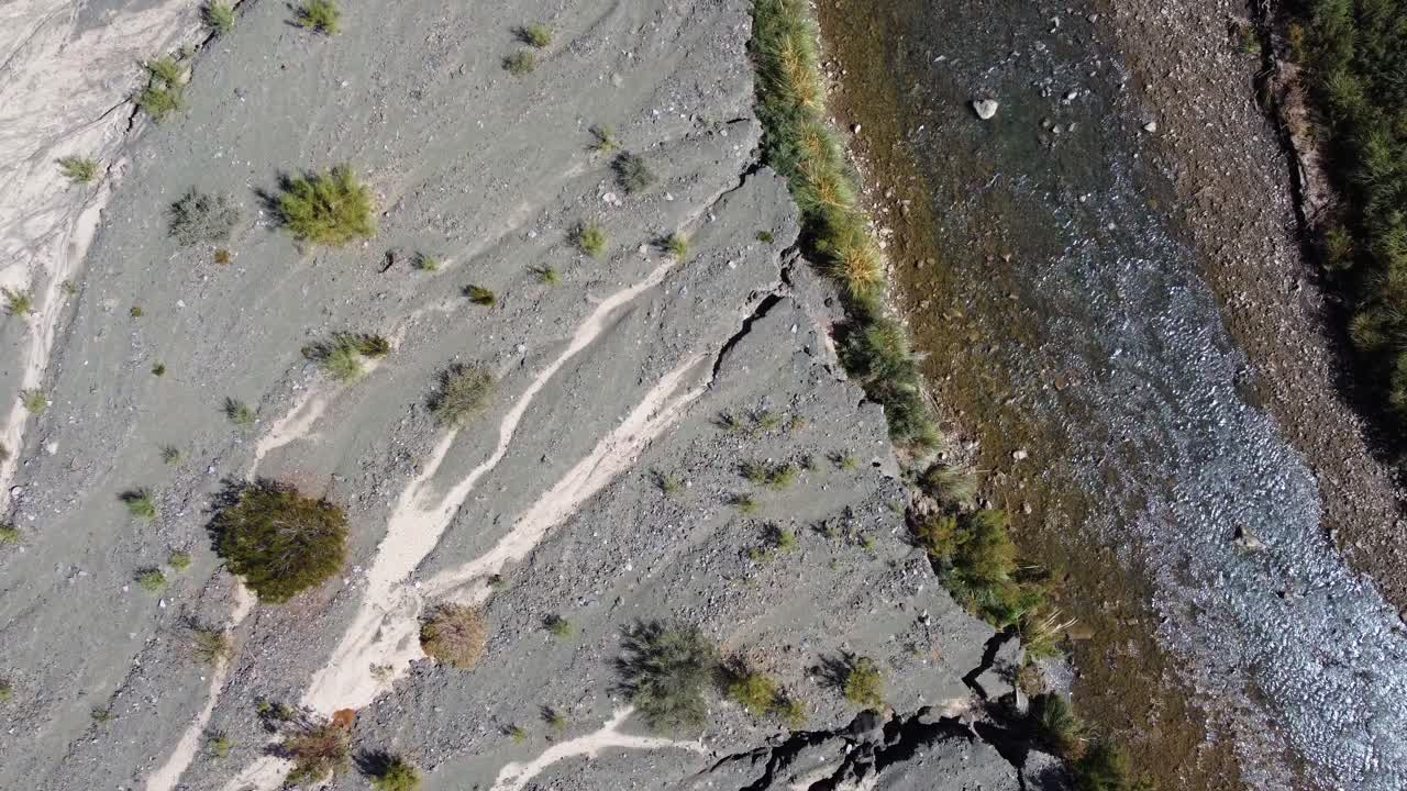 Bird's eye view of shallow rocky river and gravel shoreline, aerial