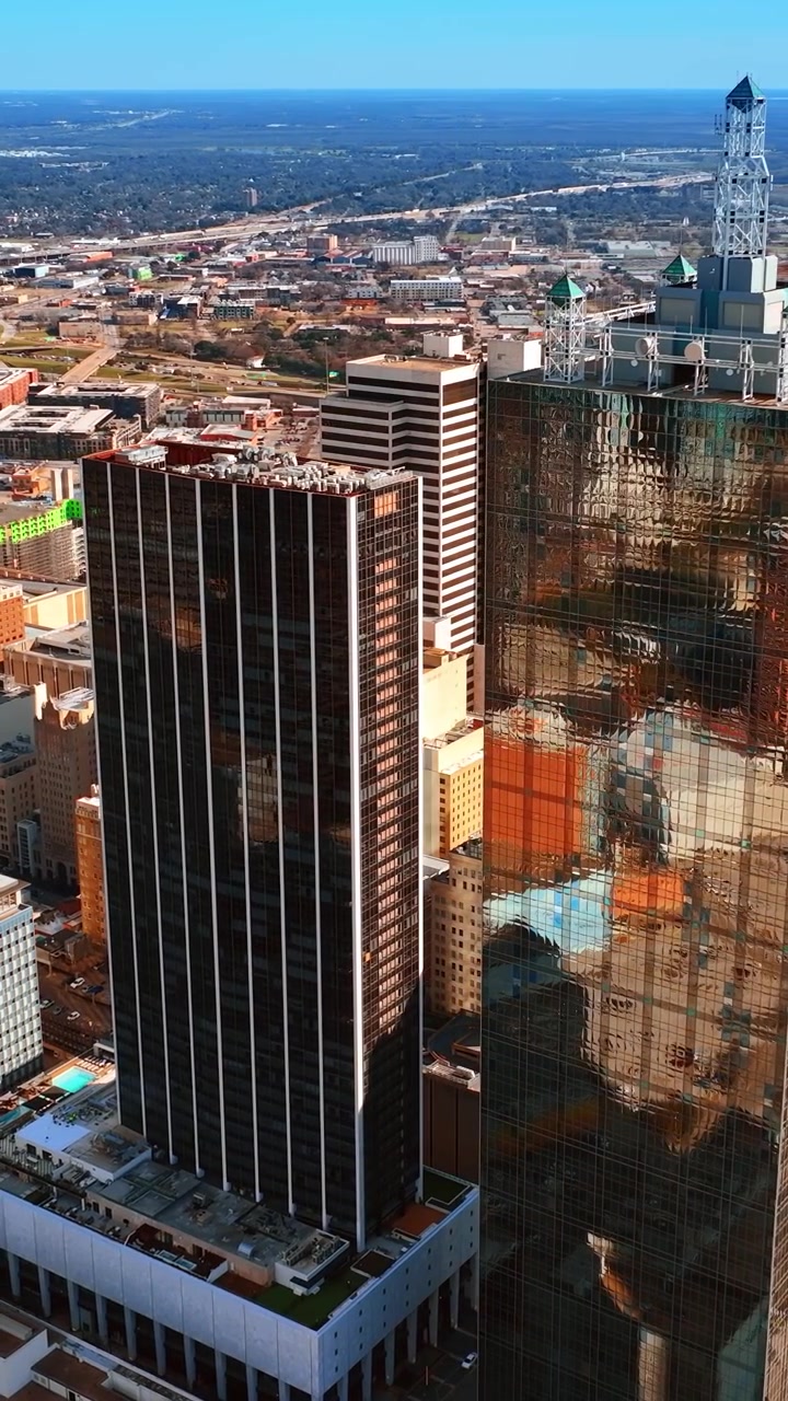 Vista dos edifícios de alturas diversas no centro de Dallas, Texas, EUA. Panorama ensolarado da cidade de uma perspectiva aérea. Vídeo vertical