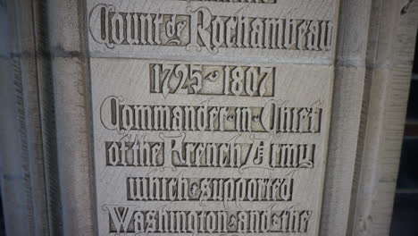 camera tilts down on gothic script engraving on stone wall expressing a patriotic and religious message