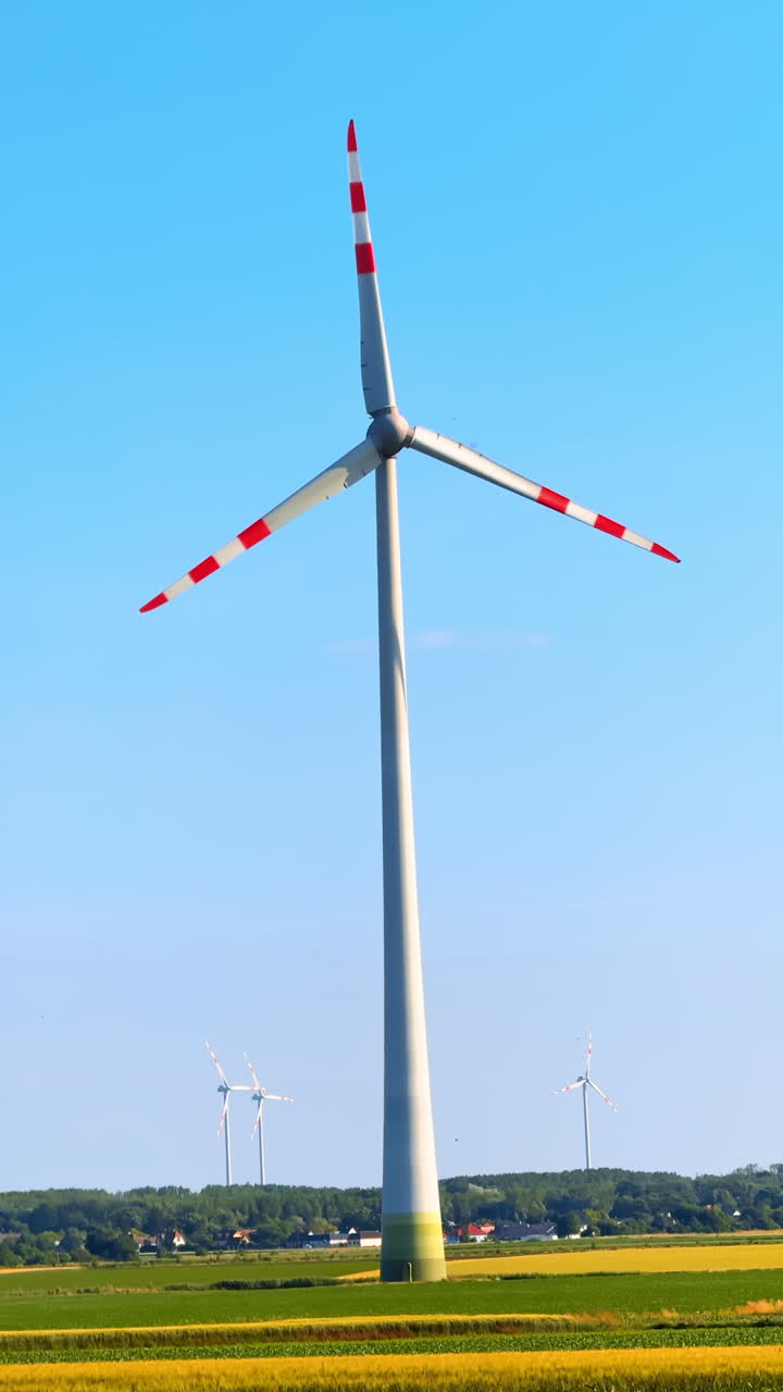 Huge wind turbine rotates in the wind. Low angle view at the wind mill producing green energy. Vertical video