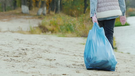 The-Girl-Carries-A-Heavy-Bag-With-Garbage-Park-Cleaning-And-Environmental-Care