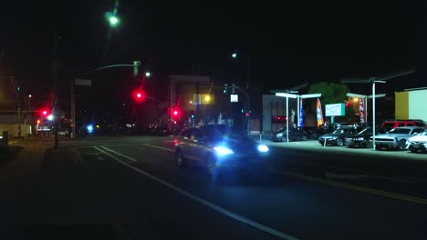 tráfico urbano ligero por la noche con luces de calle y coches que pasan