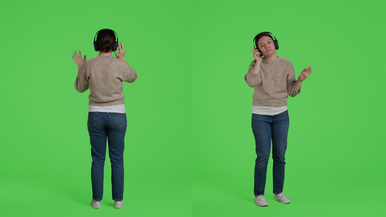 Mulher dançando e ouvindo música com fones de ouvido em frente a um plano de fundo verde