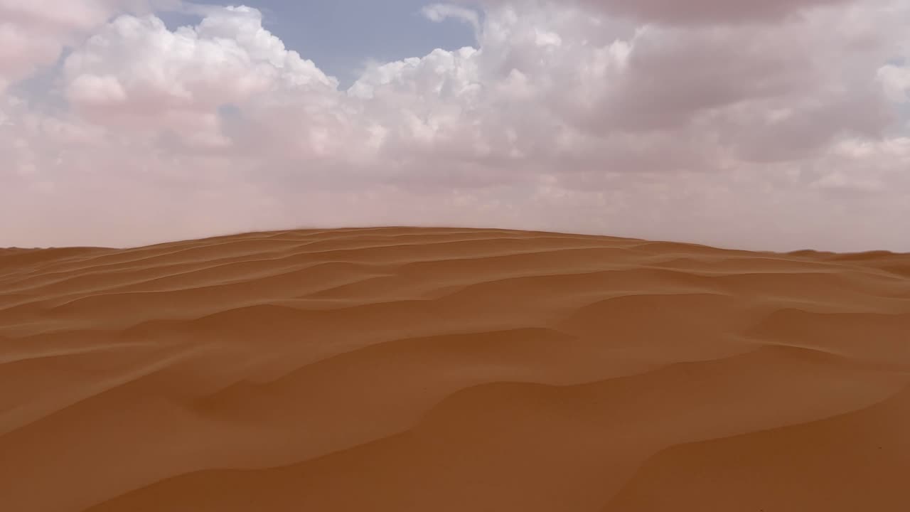 Sabbia che soffia su una duna del deserto del Sahara in una giornata ventosa e nuvolosa