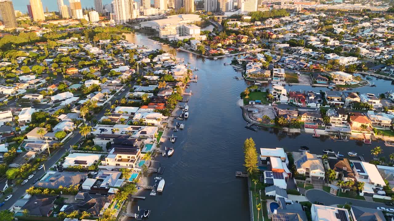 Drone footage captures Broadbeach's waterways and skyline during sunset, highlighting urban architecture and serene water reflections
