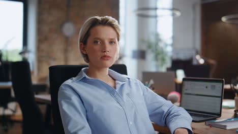 portrait confident businesswoman sitting modern office. lady boss looking camera