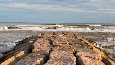 waves breaking in front of the granite jetty