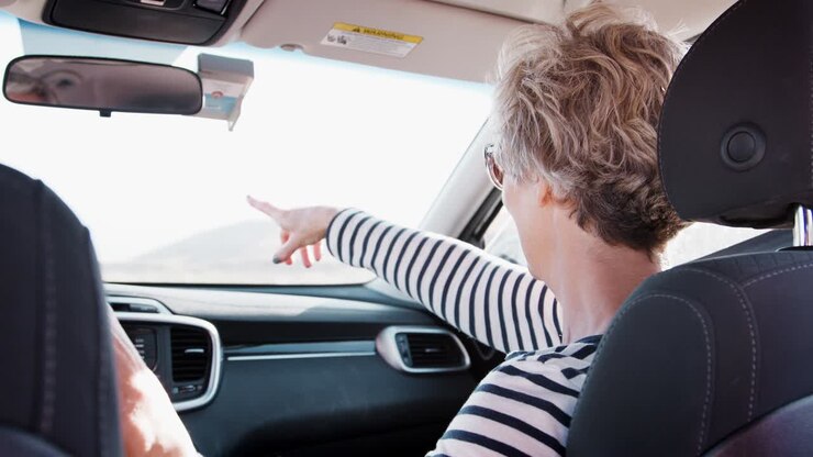 Woman in front passenger car seat, hand on driverÕs shoulder
