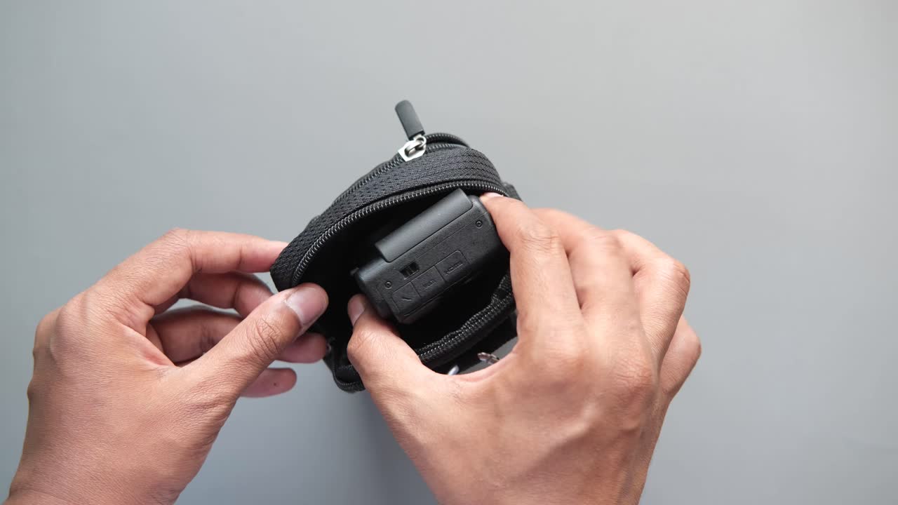 Hands Opening a Small Camera Case