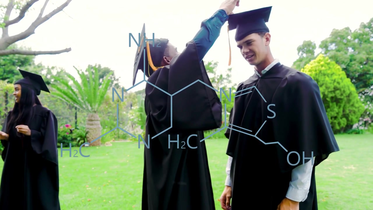 Un graduado se acerca, agitando y ajustando la borla en la graduación, con una superposición química cerniéndose sobre sus compañeros.