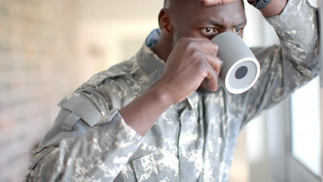 young african american soldier in military uniform enjoys a coffee at home