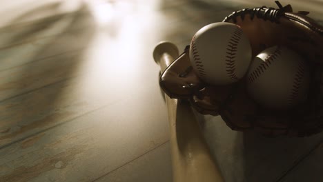 backlit close up studio baseball still life with bat ball and catchers mitt on aged wooden floor 1