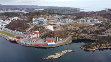 ge healthcare industrial area and production facilities in lindesnes norway - panoramic aerial showing massive plant with smoke coming from chimneys and ocean background