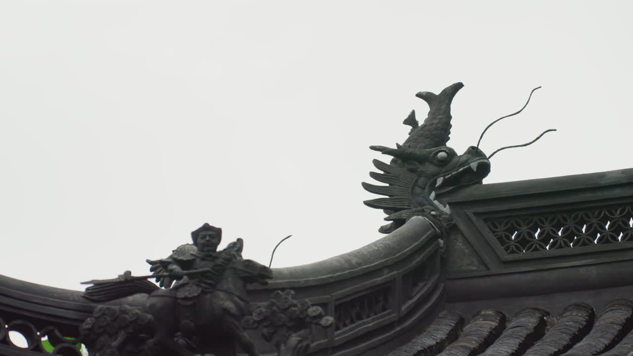 Scultura di drago sul tetto ornato di un tempio, primo piano contro il cielo di un guardiano intagliato su una grondaia curva, con colmo piastrellato e patina invecchiata; luce cupa e nuvolosa, composizione cinematografica per una narrazione architettonica.