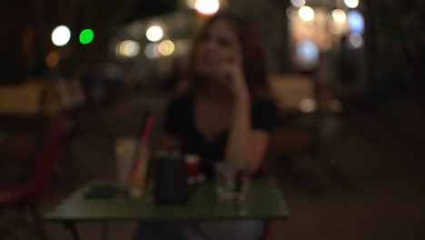 mujer bebiendo café en una cafetería nocturna