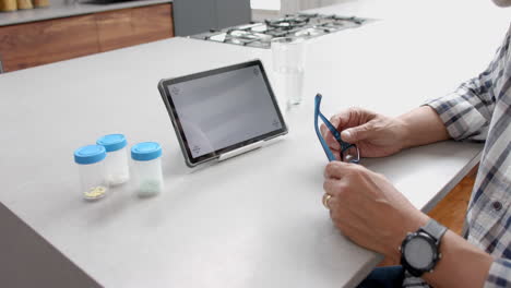 senior biracial man having medical video call on tablet, copy space screen, slow motion