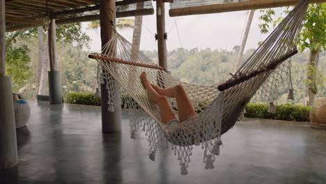 Mujer-Feliz-En-Una-Hamaca-Balanceándose-Pacíficamente-En-Un-Perezoso-Día-De-Verano-Disfrutando-Del-Estilo-De-Vida-De-Vacaciones-En-El-Complejo-Vacacional