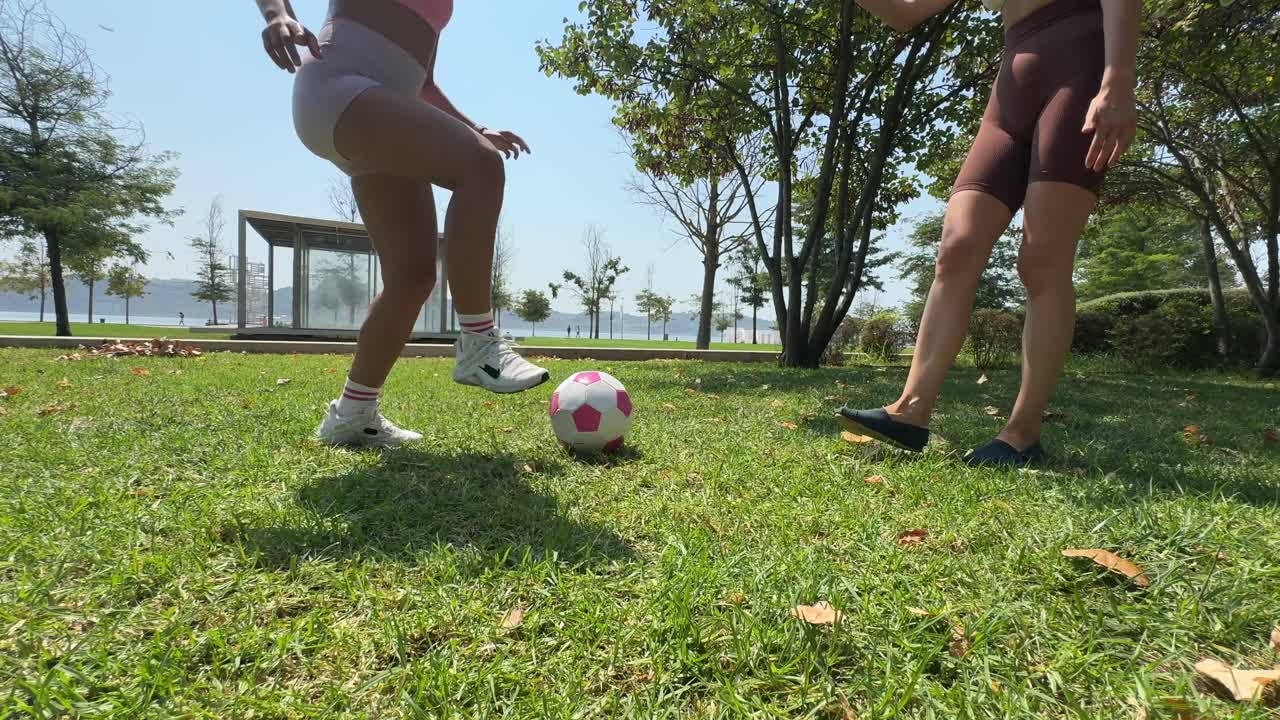 Women playing soccer in the park
