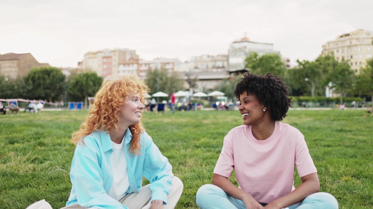 Two Happy Young Women Talking and Smiling in a City Park