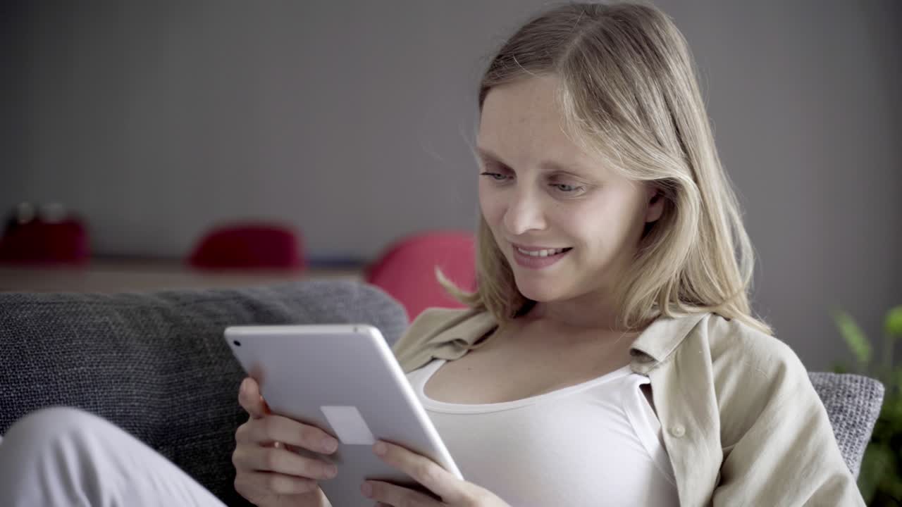 mujer joven y hermosa sonriendo usando una tableta en casa