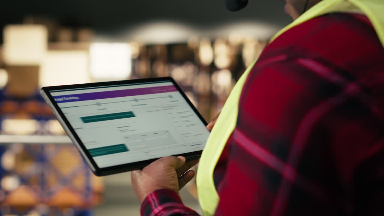 Woman in Headset Using Tablet for Package Tracking in Warehouse