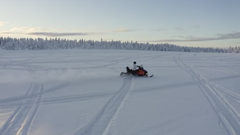 Toma-Aérea-De-Drones-En-Cámara-Lenta-Siguiendo-A-Un-Motonieve-Con-Velocidad-En-Nieve-Profunda-En-El-Frío-Paisaje-Invernal-De-Suecia