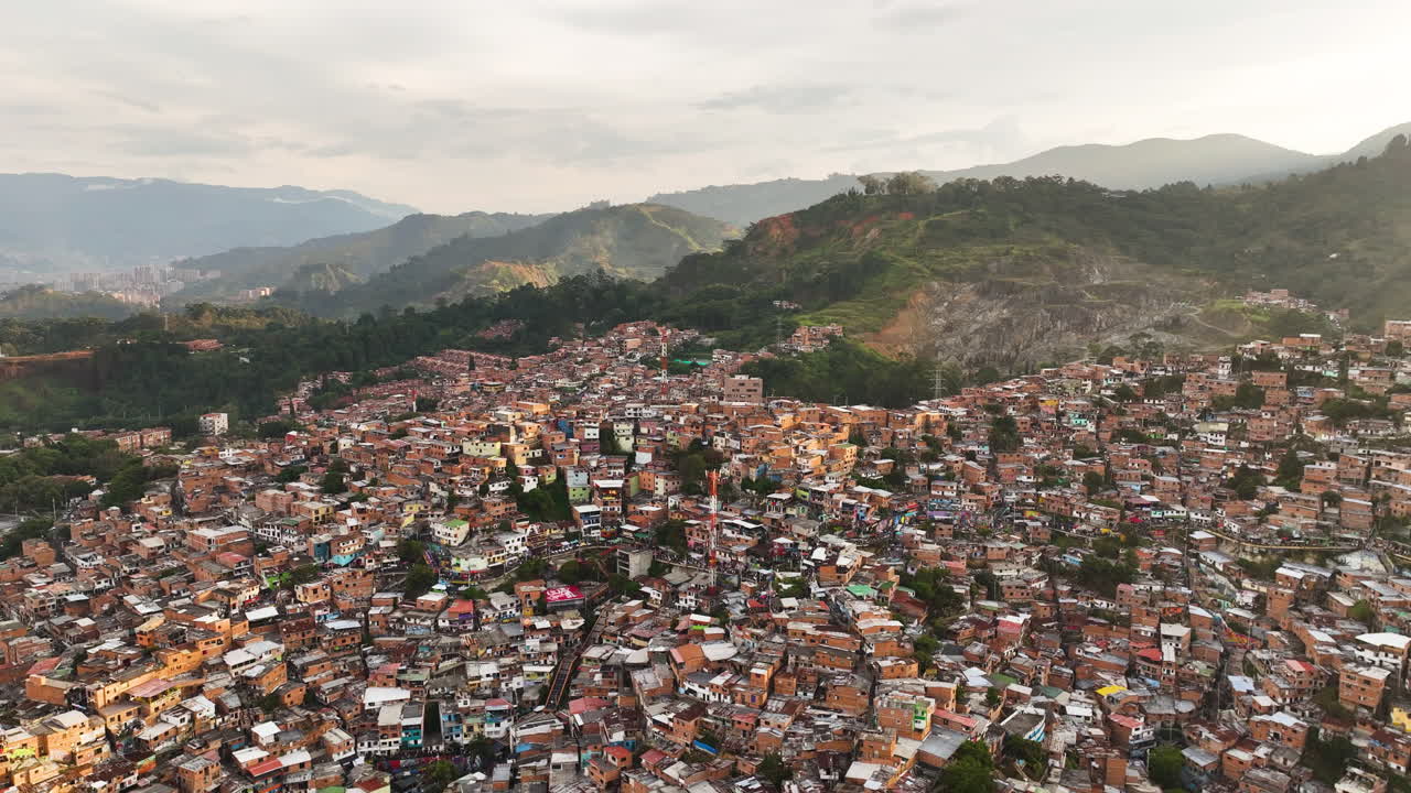 Drone shot over hills full of ghetto dwellings in Commune 13, sunset in Colombia