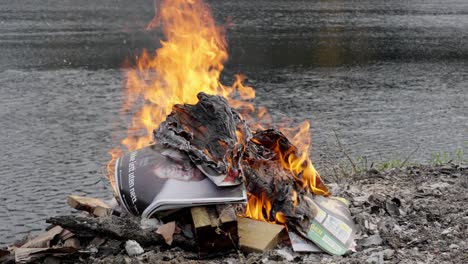 burning magazines in a bonfire by the river