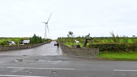 car passing by wind turbine in rural dunkeld