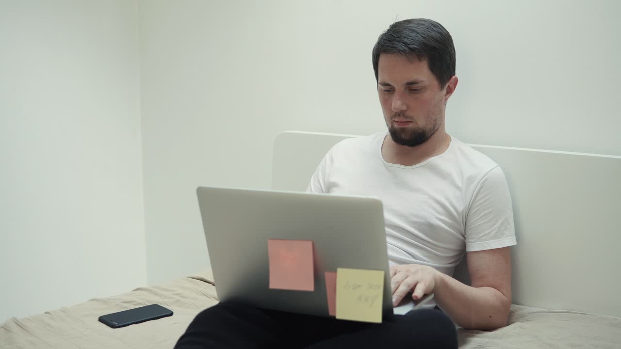 hombre trabajando en la computadora portátil en la cama