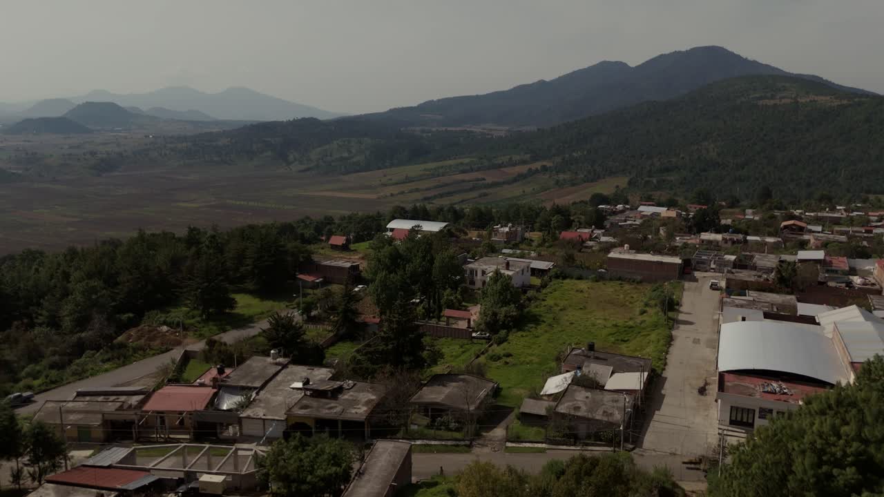 drone aéreo filmado en méxico michoacan, con bosque y fondo de la ciudad vieja