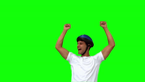 man on his bicycle raising arms on green screen