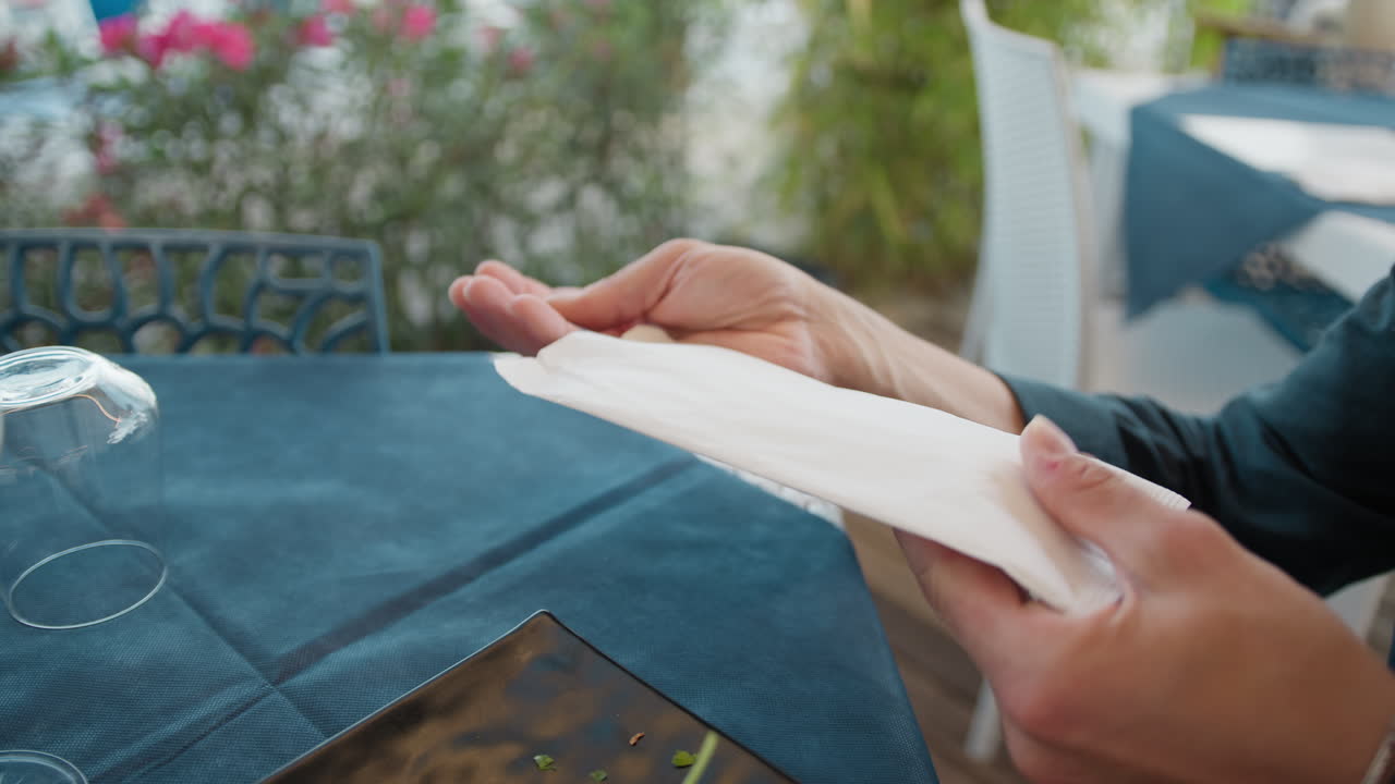 Hand Of A Man Picking Up Fork And Knife From The Restaurant Table