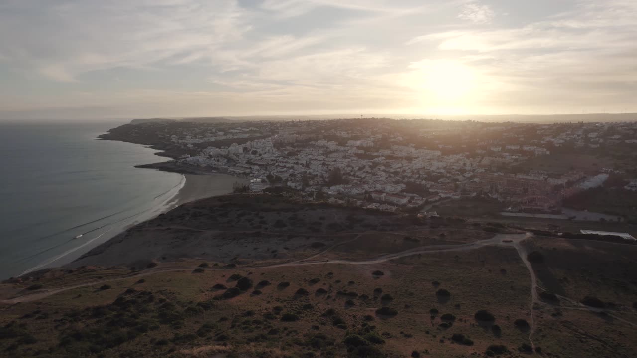 Ampia ripresa aerea in allontanamento sul paesaggio di Praia da Luz, Algarve al tramonto