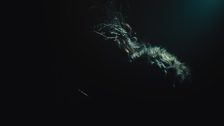 A creepy witch stands in the moody pose during the night storm