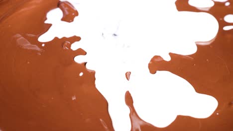 líquido blanco se mezcla en la superficie del chocolate marrón