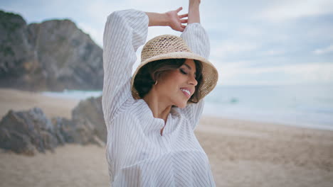 hermosa chica disfruta de la brisa en la playa de verano. mujer soñadora sonriente cerrando los ojos