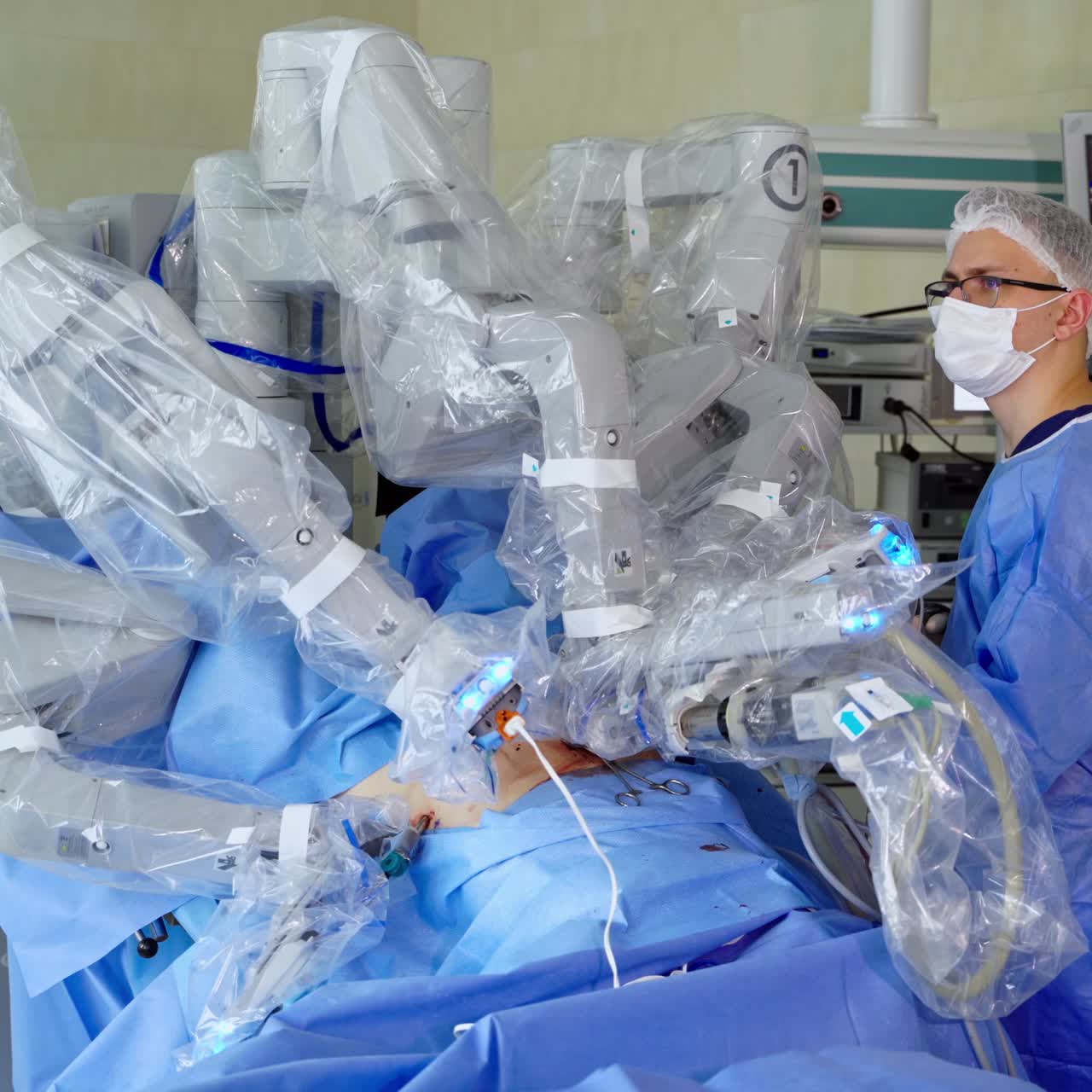 Surgery with hi-tech equipment. Surgical robot perform minimally invasive operation to a patient. Professional surgeon in medical uniform near the robotic machine in hospital