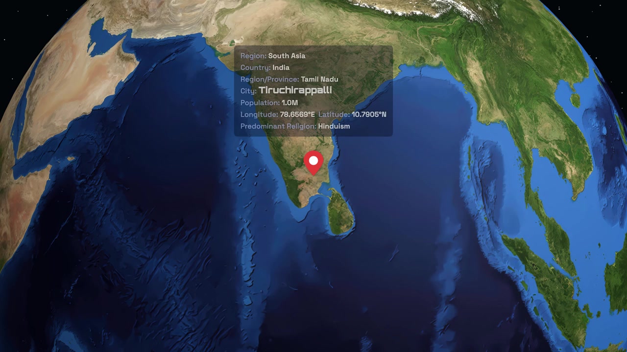 A digital globe rotates and zooms into Tiruchirappalli, India, displaying regional geographic data points