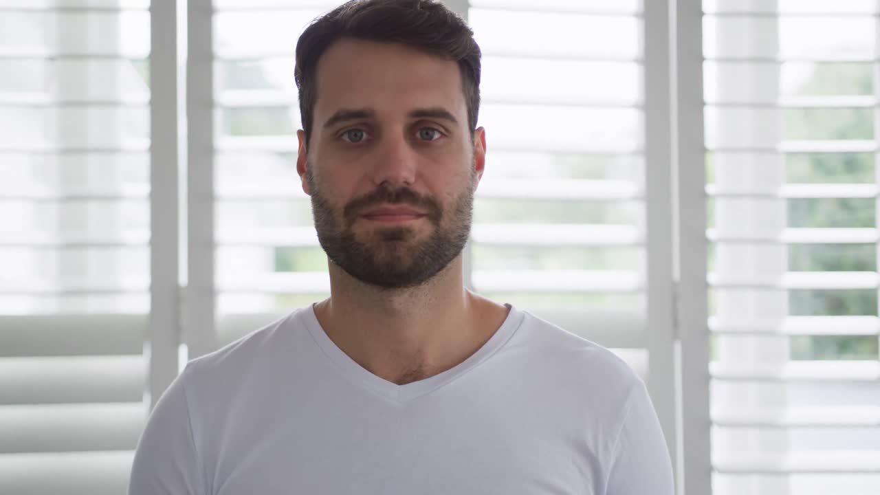 Uomo che guarda la telecamera in una casa accogliente 4k
