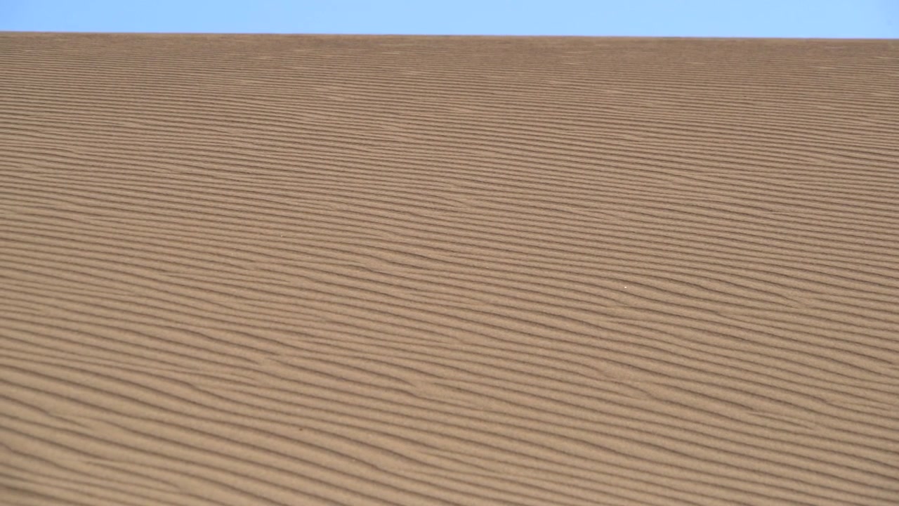 Dune di sabbia ondulate sotto un cielo azzurro sereno
