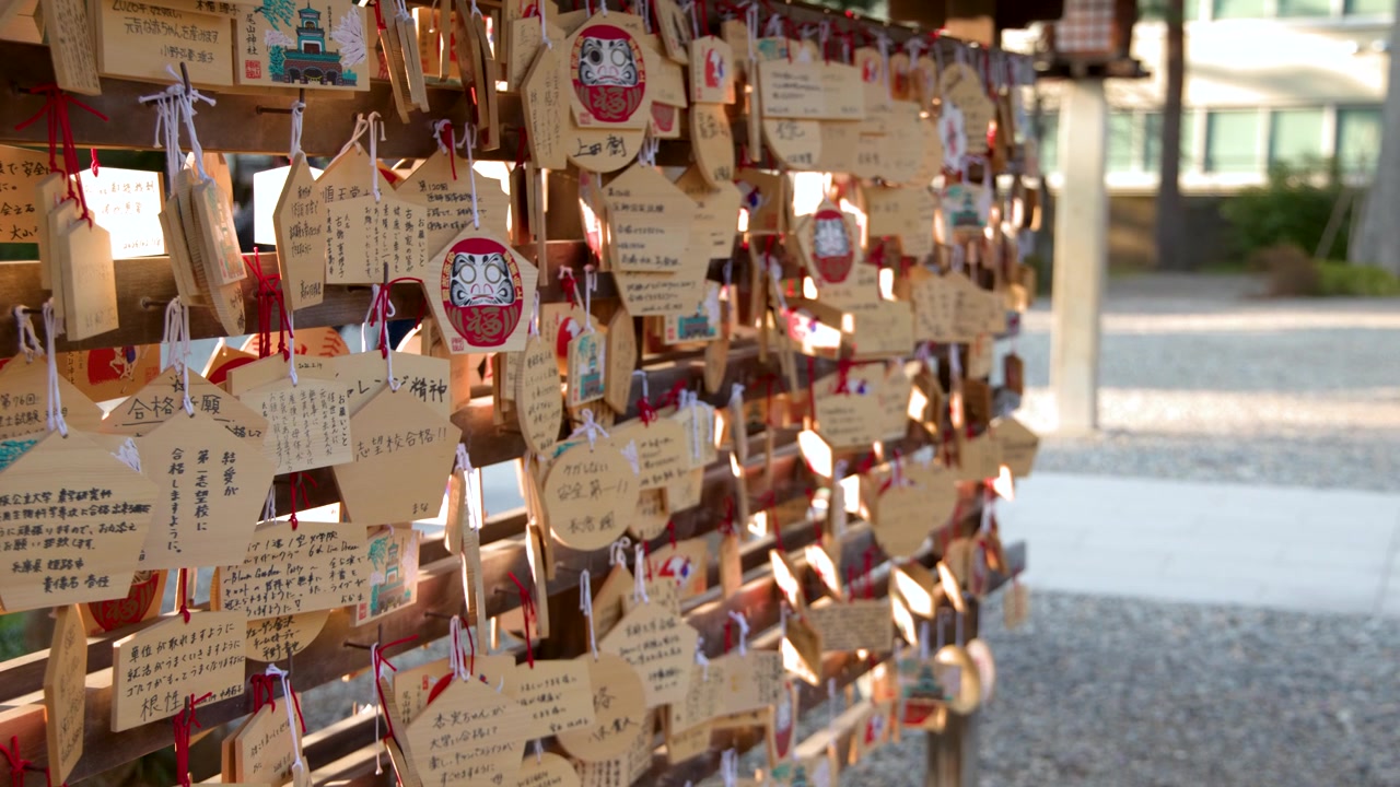 Un lent panoramique de caméra révèle des rangées de plaques votives en bois dans un sanctuaire shintoïste japonais.