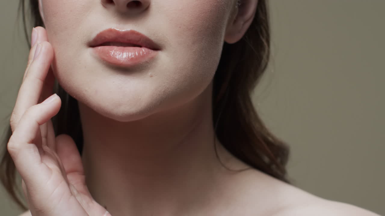 mujer caucásica con cabello marrón tocando la cara, copiar el espacio, cámara lenta