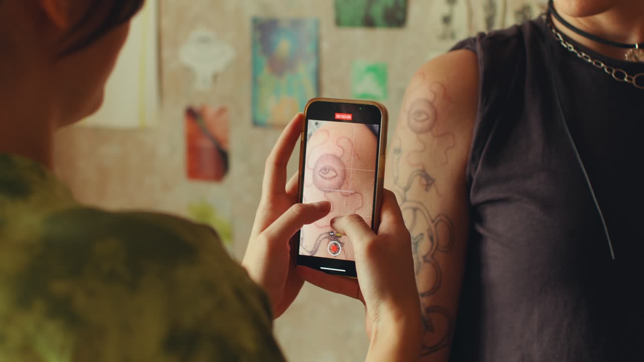 Female Artist Photographing Tattoo on Client in Salon